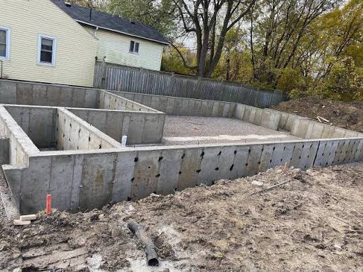Completed 4-foot poured concrete frost wall foundation with gravel base and drain tile by Kuphal Concrete