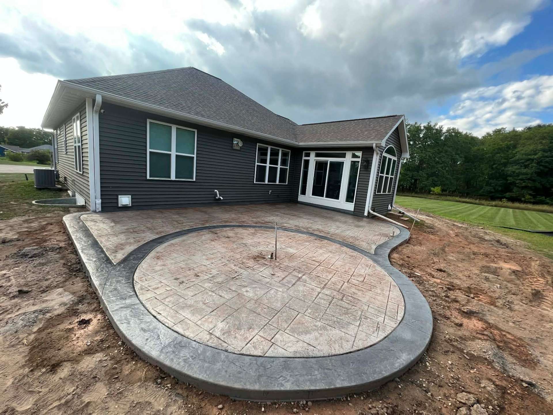 Freshly poured concrete driveway being finished with a trowel at a Midwest residential home